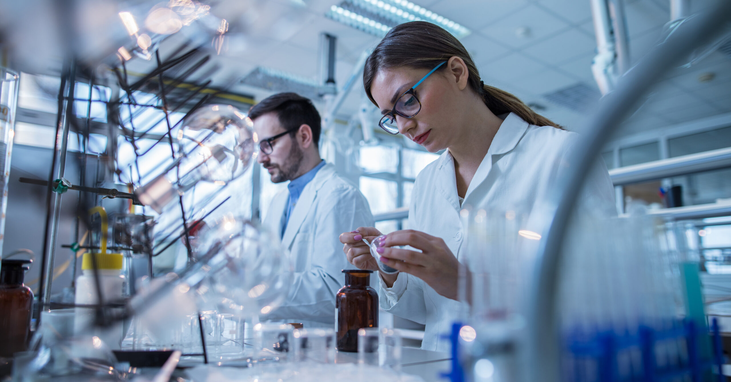 Young biochemists working with laboratory equipment during scientific experiment.